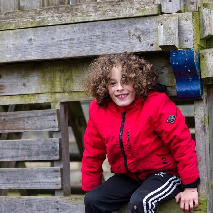 Young lad playing to the Blacon Adventure Playground treehouse