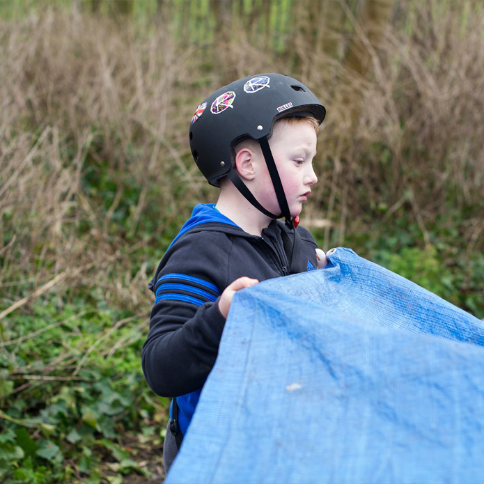 Young lad building a base at the Blacon Adventure Playground